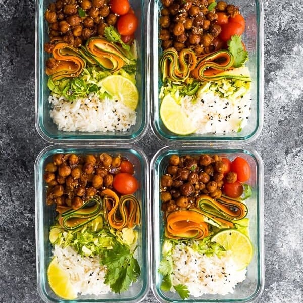 overhead shot of four glass meal prep containers filled with korean bbq chickpea bento