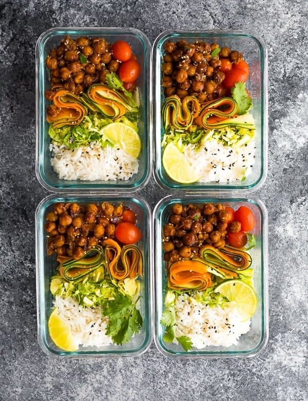 overhead shot of four glass meal prep containers filled with korean bbq chickpea bento