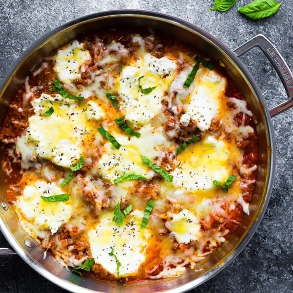 overhead shot of large pot filled with lasagna skillet and fresh basil