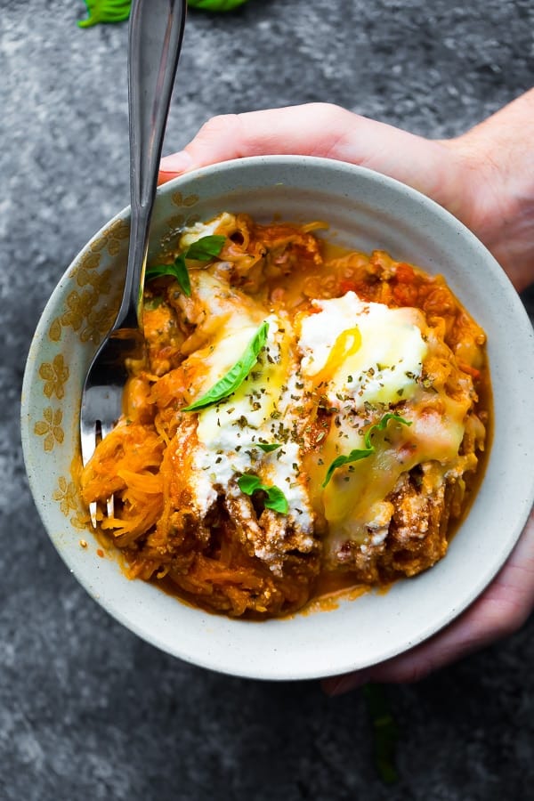 holding a bowl of low carb lasagna skillet