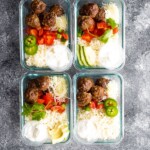 overhead shot of four glass meal prep containers with low carb meatball burrito bowls