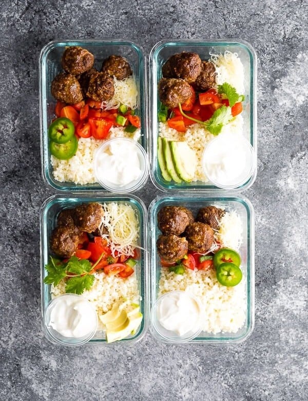 overhead shot of four glass meal prep containers with low carb meatball burrito bowls