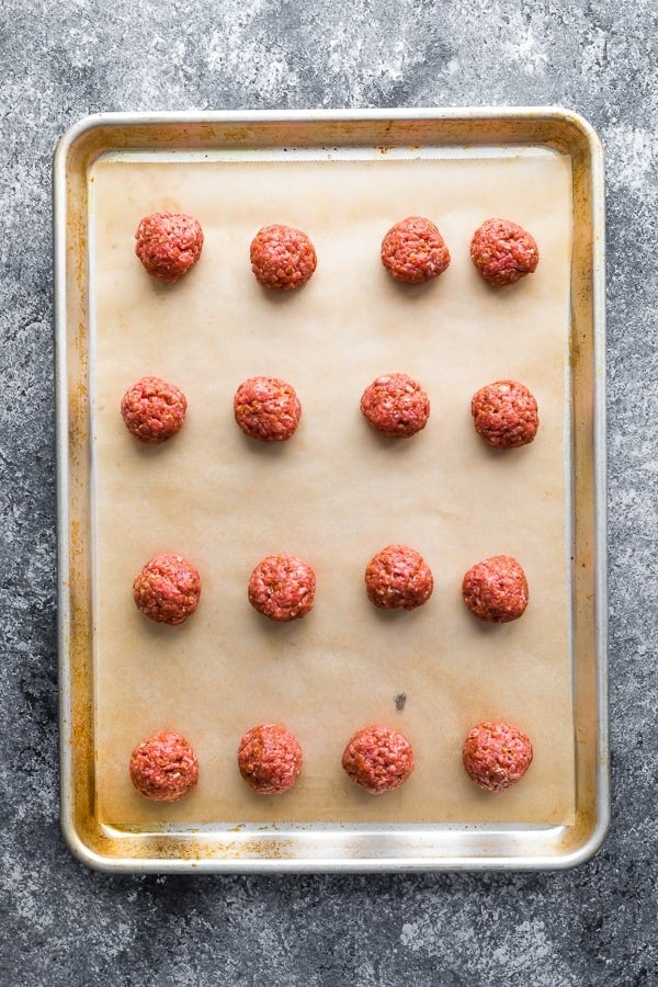 overhead shot of rows of meatballs on sheet pan