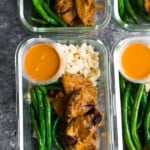 overhead shot of satay beef with green beans in four glass meal prep containers