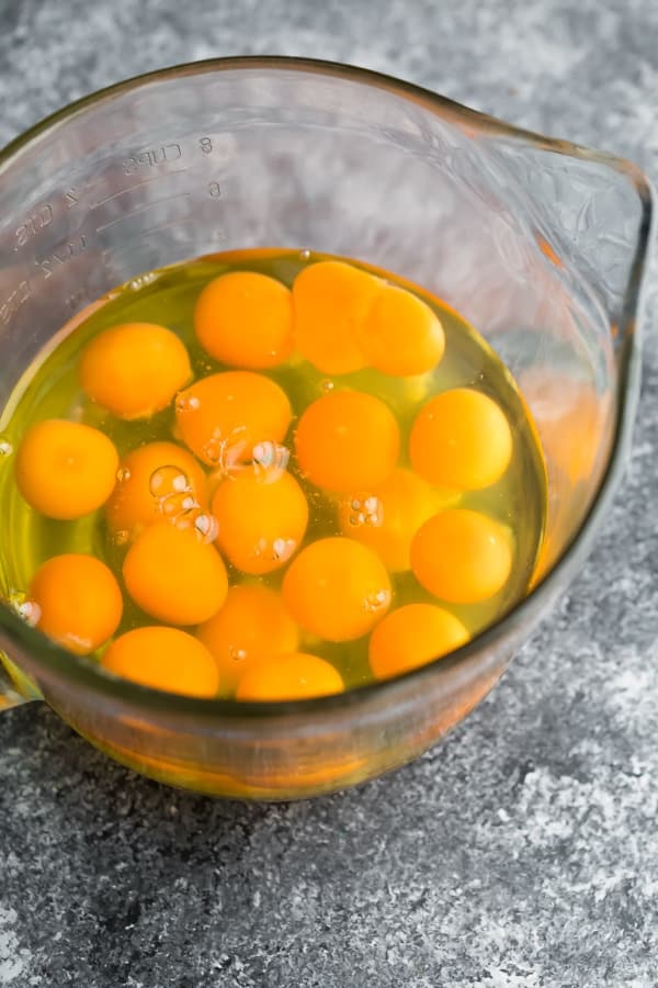 eggs cracked into a glass measuring bowl for the meal prep eggs recipe