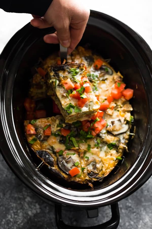 slow cooker breakfast casserole being scooped out of the slow cooker