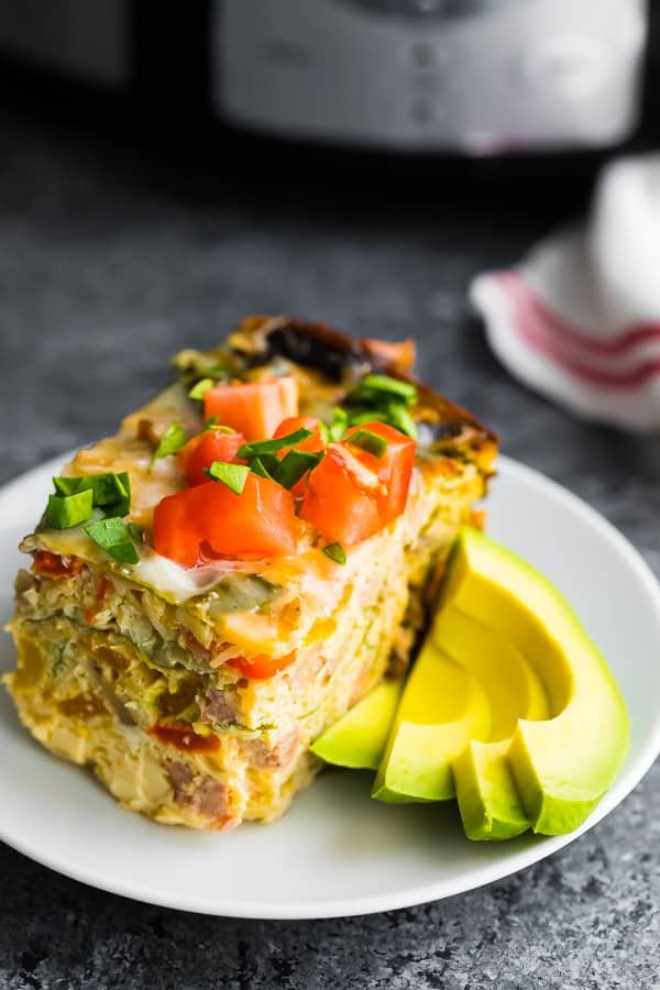 crockpot breakfast casserole on plate with sliced avocado