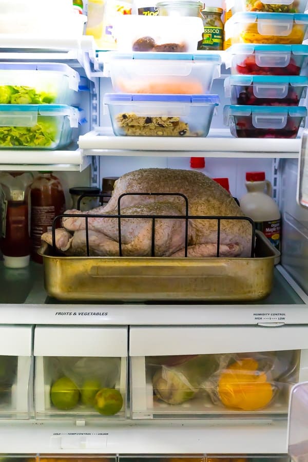 refrigerator shelves stocked with the turkey and other make ahead thanksgiving prep containers