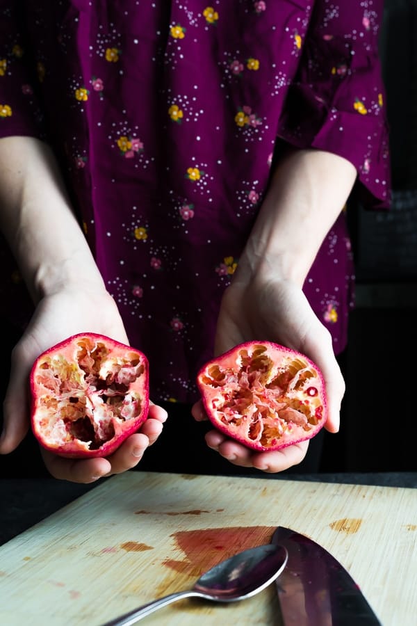 a hand holding an empty pomegranate rind.