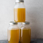 three glass stacked mason jars filled with turkey bone broth