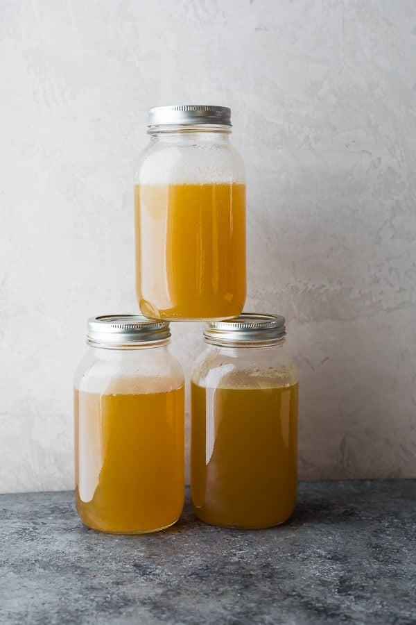 stack of three quart-sized glass mason jars filled with bone broth