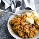 make ahead apple crisp in a white bowl with ice cream and a spoon