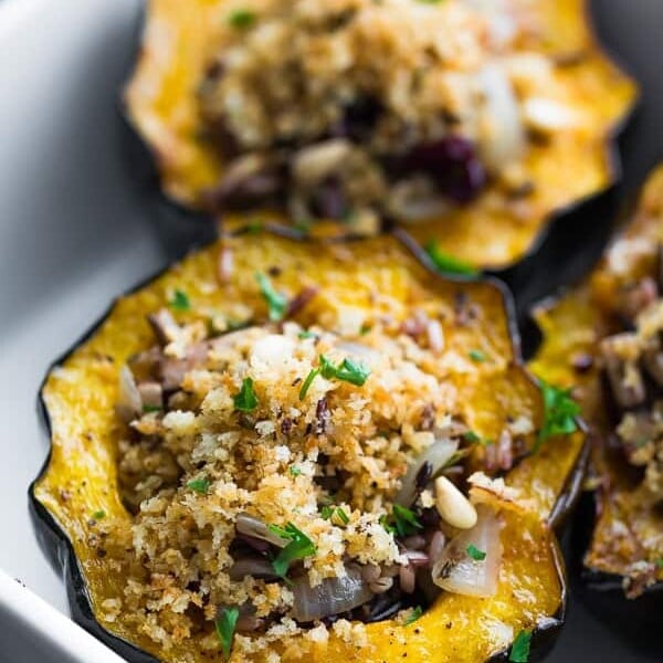 close up shot of stuffed acorn squash with mushrooms and cranberries