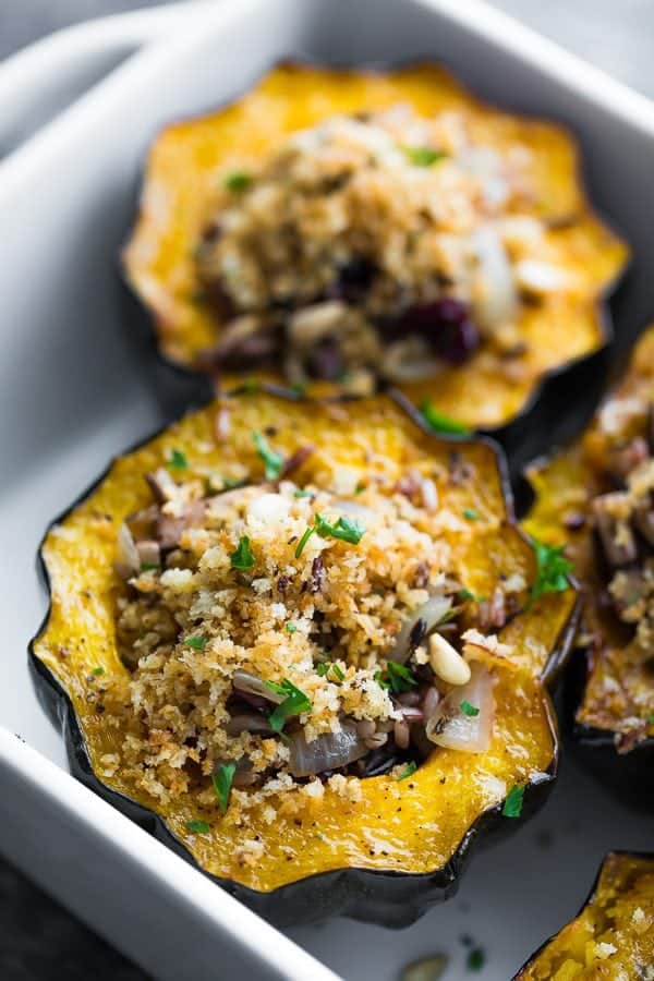 close up shot of stuffed acorn squash with mushrooms and cranberries
