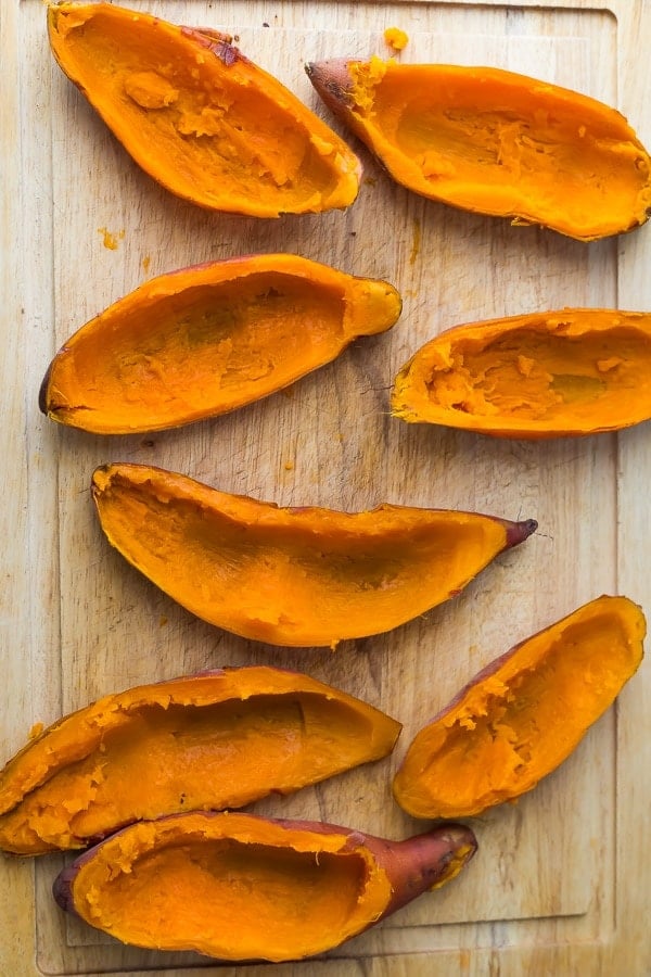 prepping the sweet potato casserole recipe by scooping out sweet potato skins