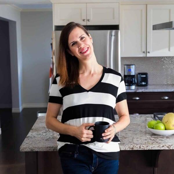 Denise in front of her kitchen with a coffee mug