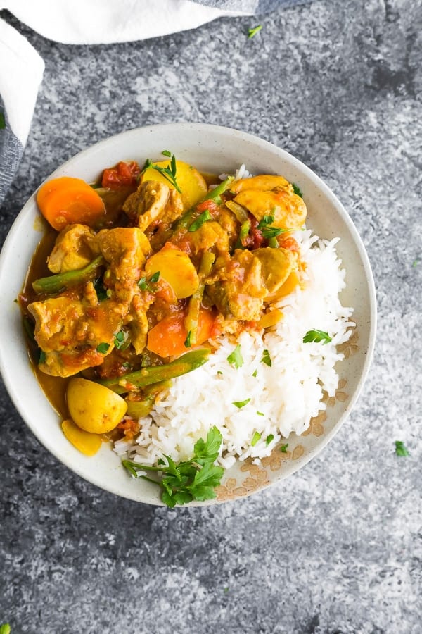 overhead view of coconut curry chicken in bowl with rice