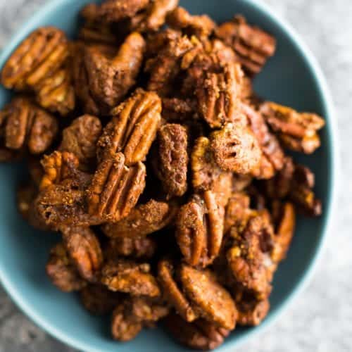 overhead shot of cinnamon roasted pecans in a blue bowl