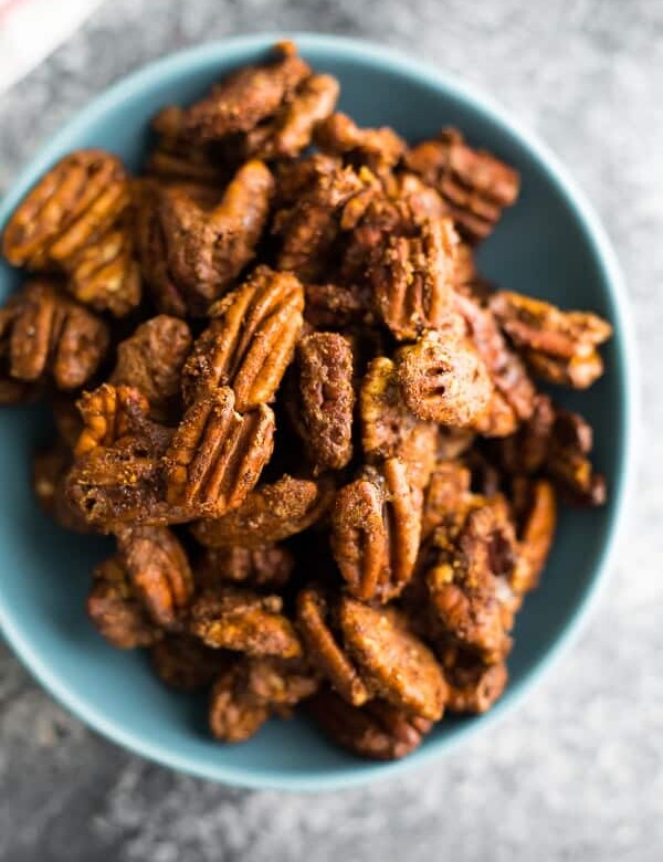 overhead shot of cinnamon roasted pecans in a blue bowl