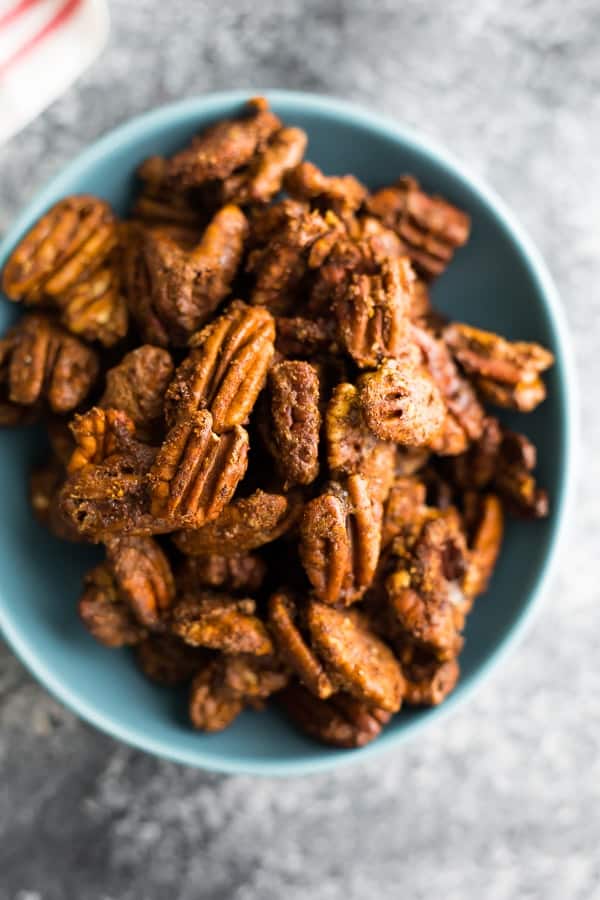 overhead shot of cinnamon roasted pecans in a blue bowl