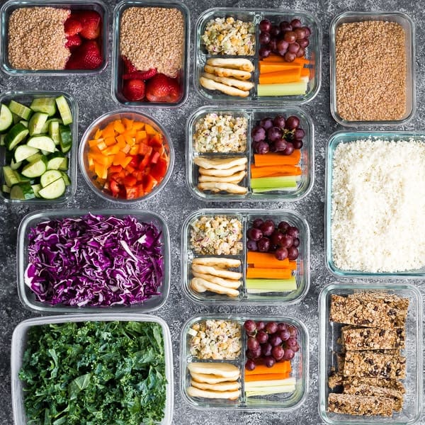 overhead view of thirteen meal prep containers with a variety of ingredients