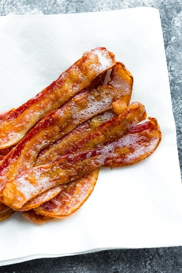 bacon draining on paper towel after baking bacon in the oven