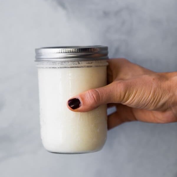 hand holding a glass mason jar with buttermilk