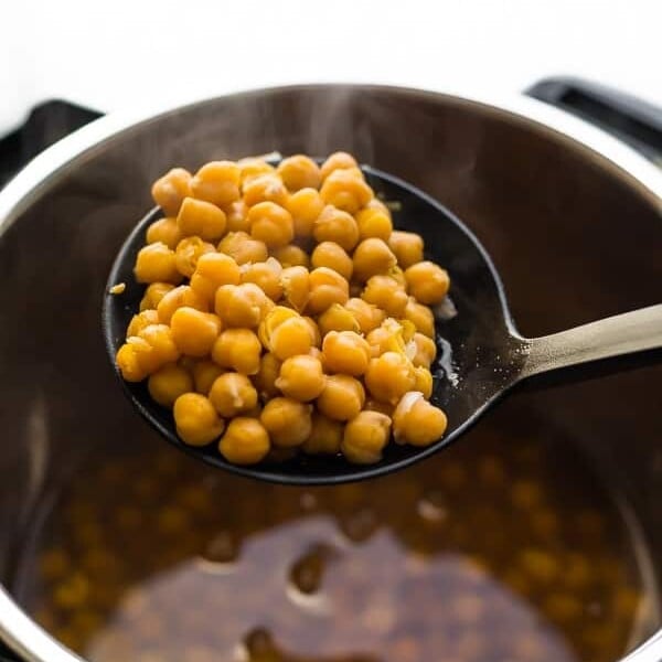 Chickpeas on a large ladle coming out of the instant pot