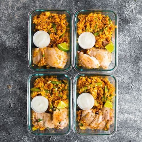 overhead shot of four glass meal prep containers with indian chicken