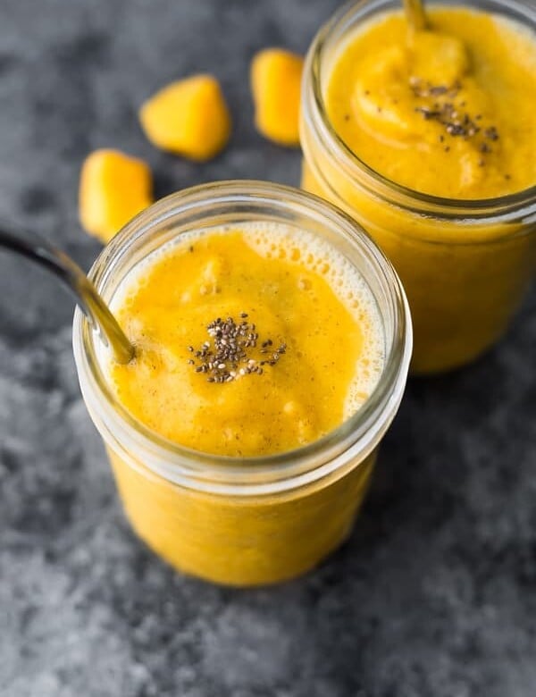 mango smoothie in glass mason jar with spoon