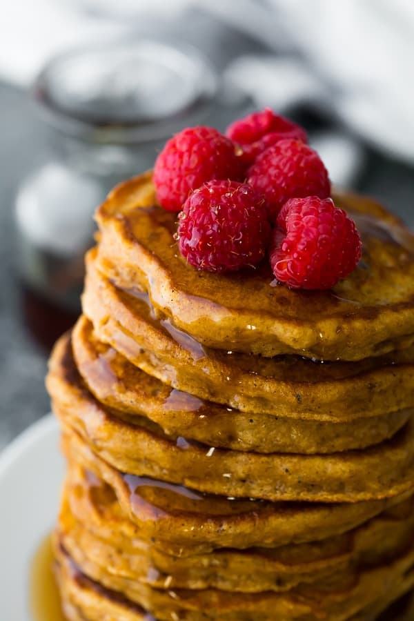 stack of sweet potato pancakes recipe with raspberries on top