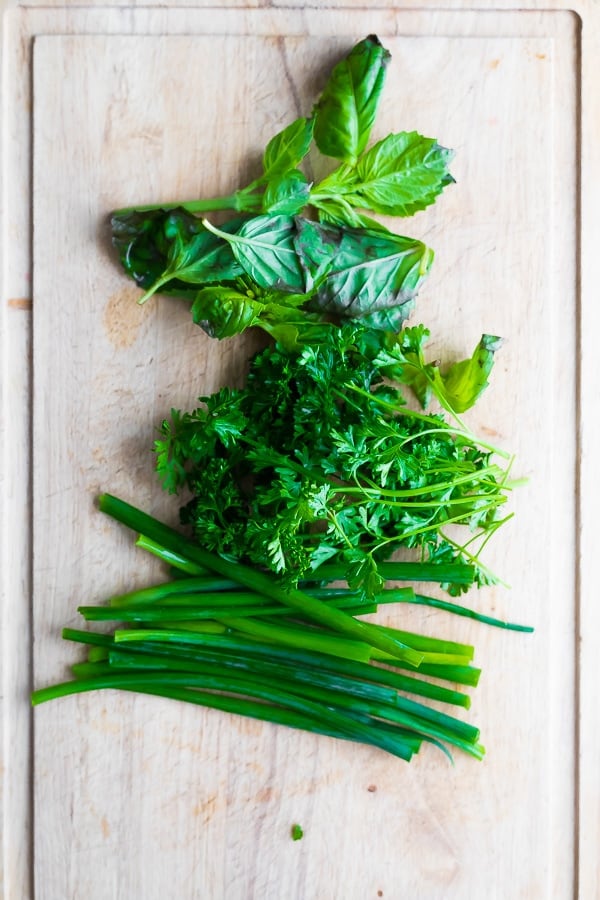 herbs chopped on a cutting board for the green goddess dressing recipe