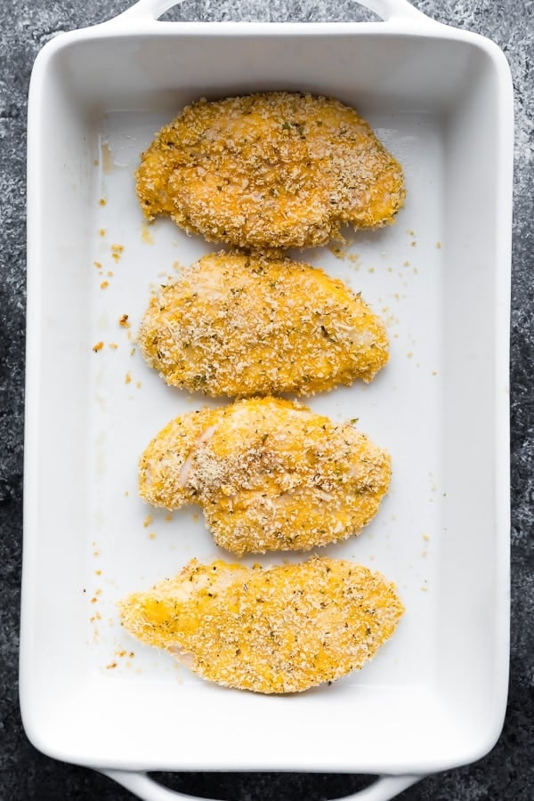 chicken breaded and in a baking dish fro the chicken parm recipe