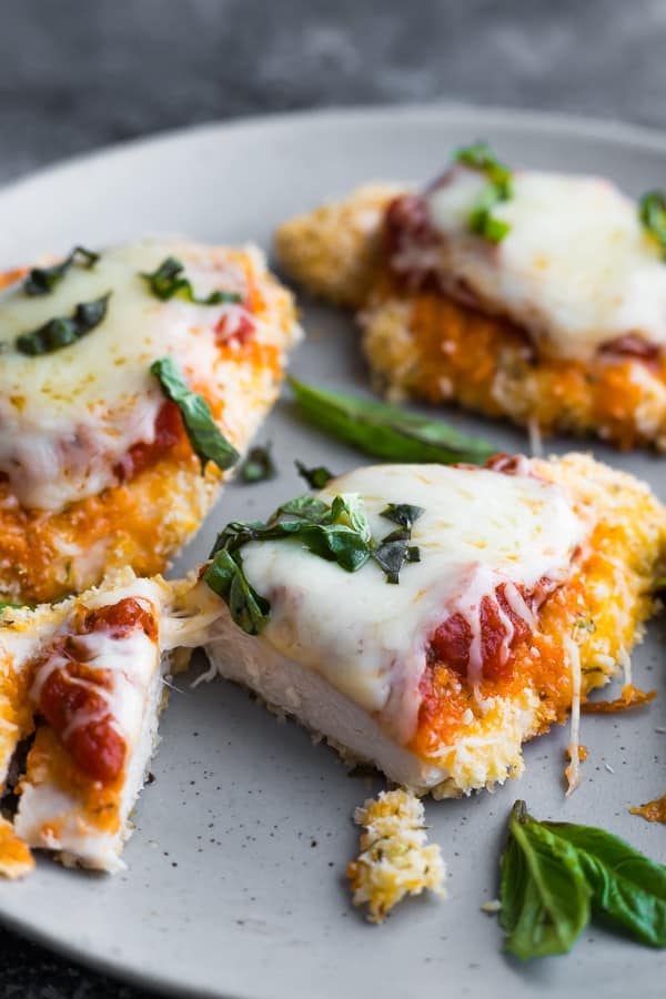 chicken parmesan recipe cut in half with melted cheese stringing between