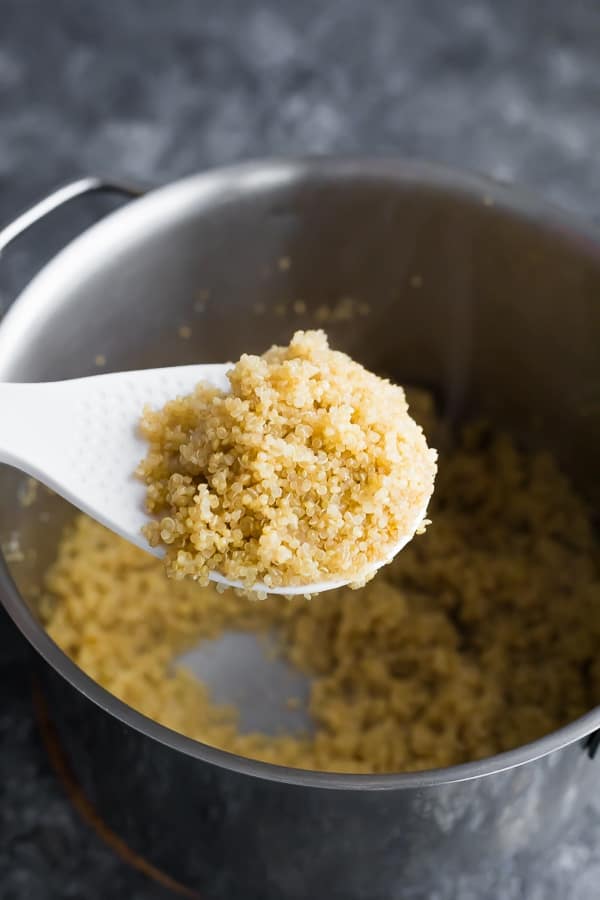 how to cook quinoa- showing perfectly cooked quinoa on white spoon