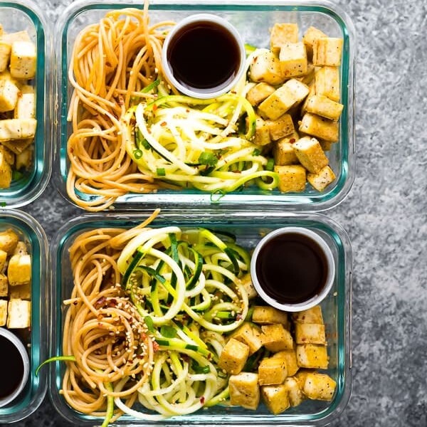 overhead shot of two glass meal prep containers filled with spicy tofu noodles