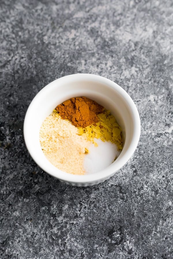 spices and nutritional yeast in white bowl on grey surface