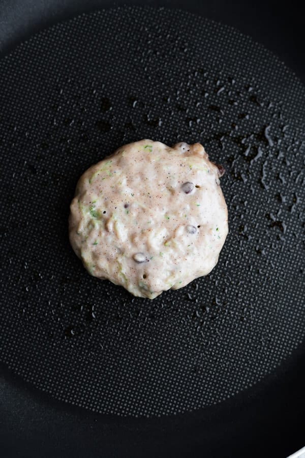 cooking the zucchini pancakes recipe in a non-stick skillet from overhead view