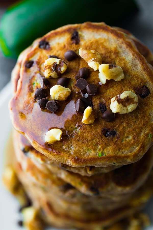 overhead view of a stack of chocolate chip pancakes with chocolate chips and walnuts on top