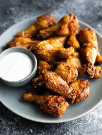 gray plate with pile of air fryer chicken wings and dipping sauce