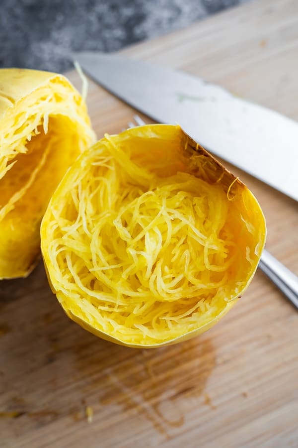 how to cook spaghetti squash- showing cooked spaghetti squash on a cutting board