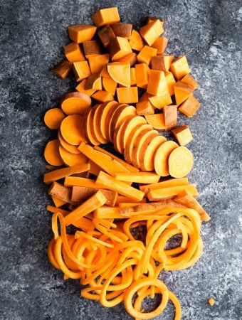 overhead shot of sweet potatoes cut in multiple ways on gray background