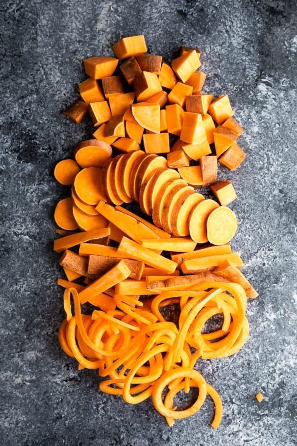 overhead shot of sweet potatoes cut in multiple ways on gray background