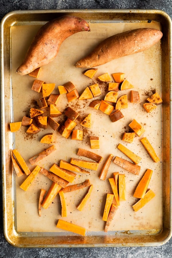 sweet potatoes on a sheet pan before cooking sweet potatoes in oven