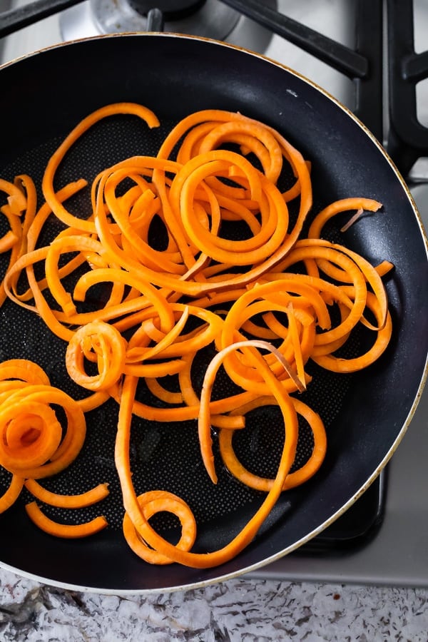 sweet potato noodles in pan showing how to cook sweet potatoes on the stove