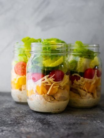 three glass mason jars filled with ranch chicken jar salads