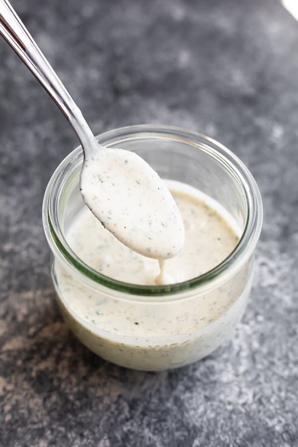 spooning the ranch dressing recipe into a jar