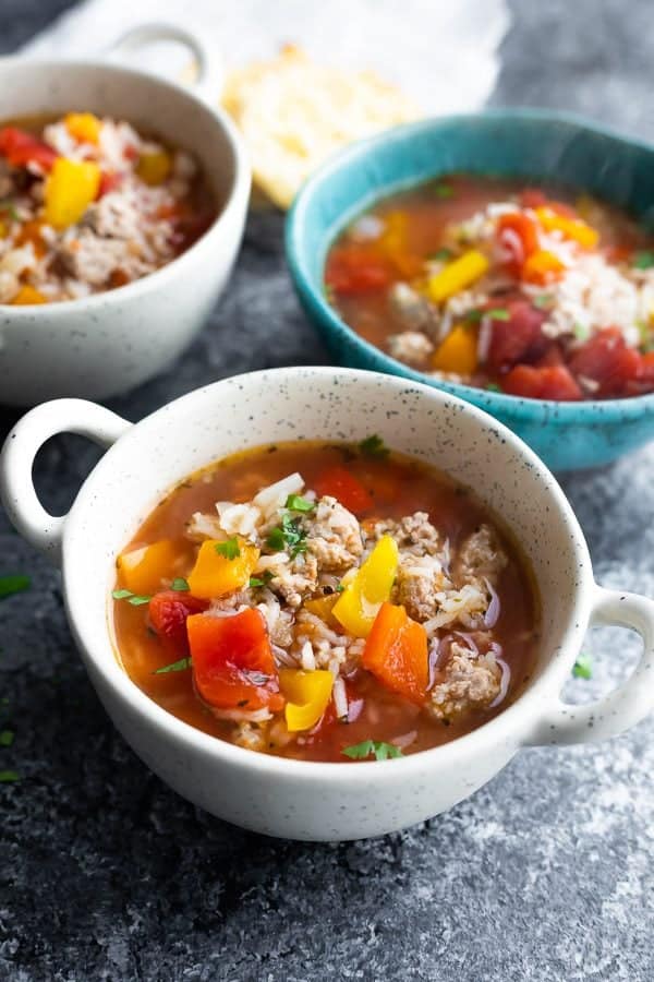 three white and blue bowls of stuffed pepper soup