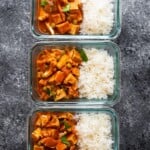 overhead shot of three glass meal prep containers filled with vegan slow cooker tikka masala