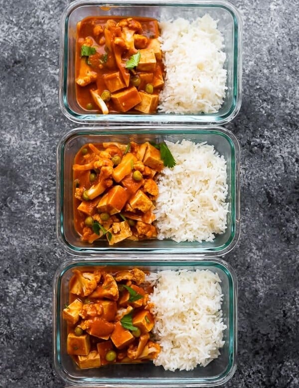 overhead shot of three glass meal prep containers filled with vegan slow cooker tikka masala